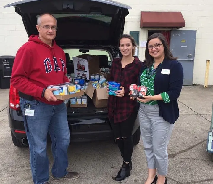 MMY volunteers holding donated food items, 2017