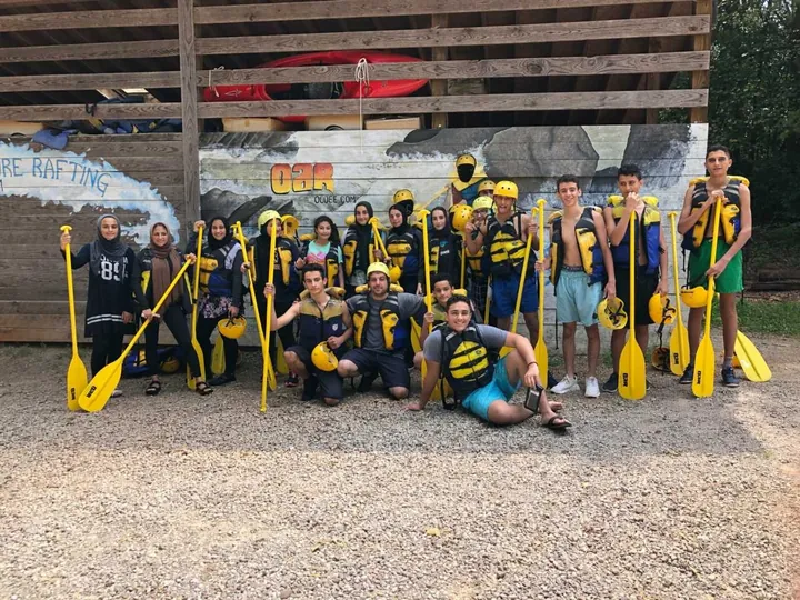 MMY youth with paddles and helmets on a rafting trip, 2018