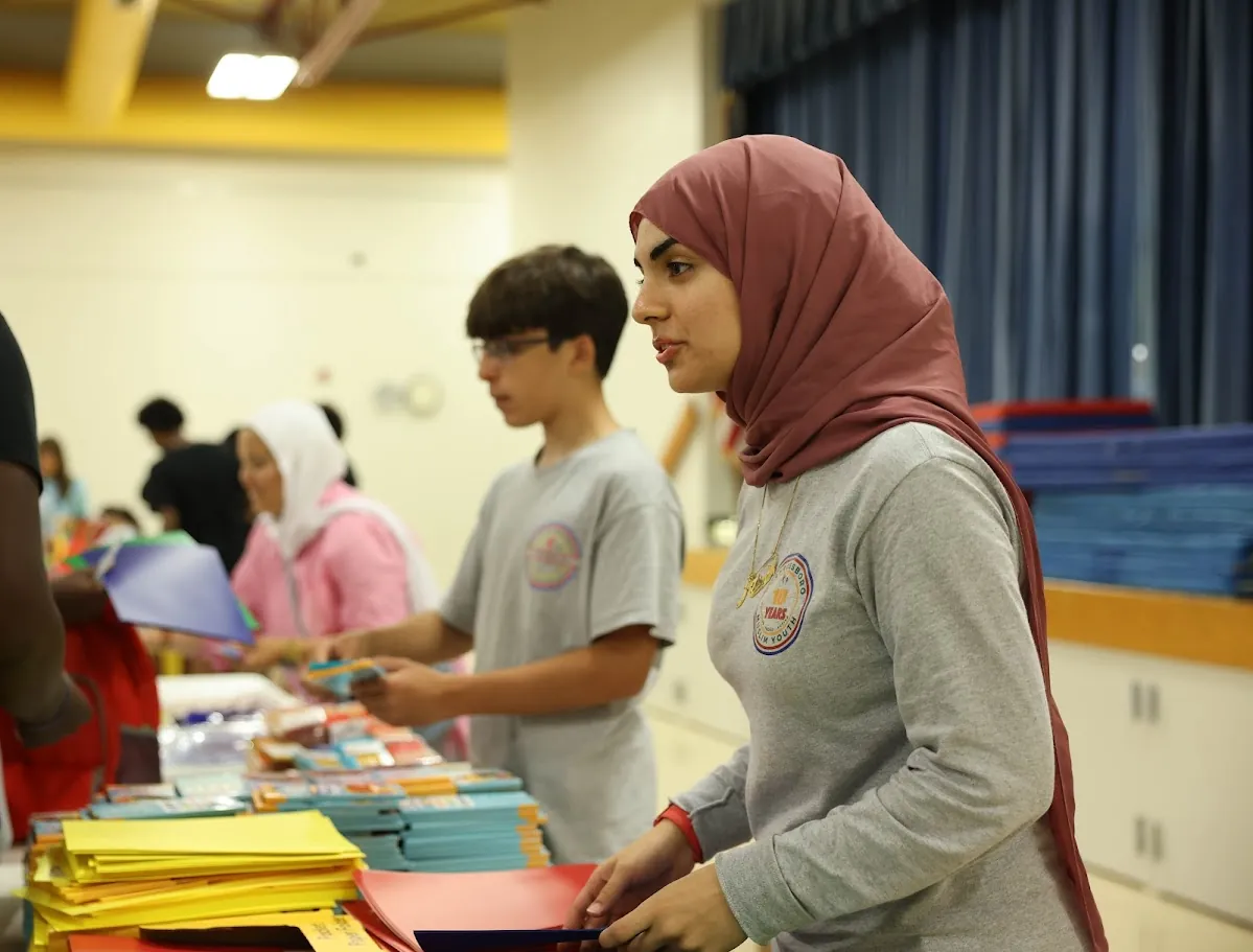 Volunteers sorting donated school supplies and coats