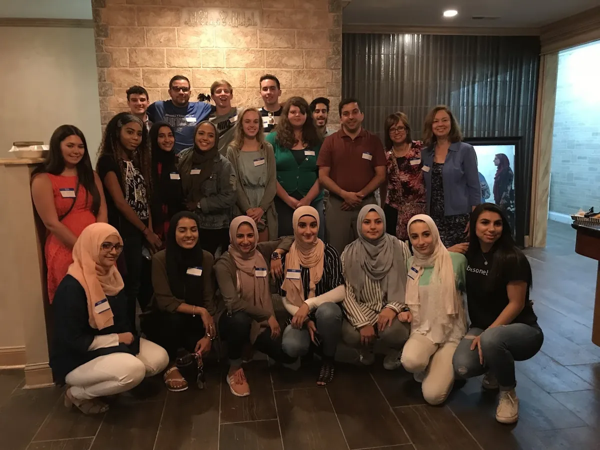 Guests of different faiths and backgrounds, wearing name tags, gathered for an A Seat at the Table dinner