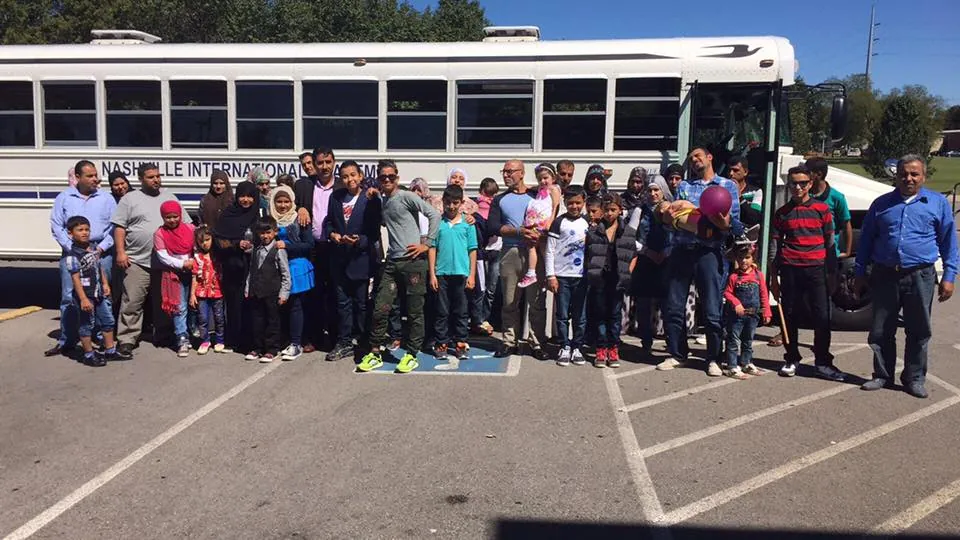MMY volunteers welcoming a refugee family