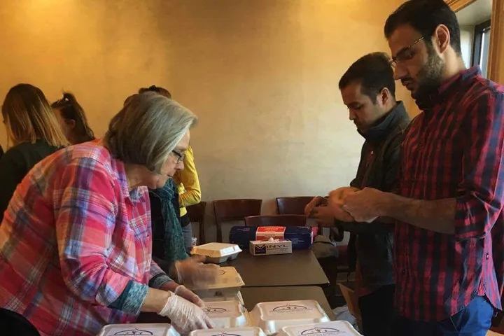 MMY volunteers packing meal boxes together