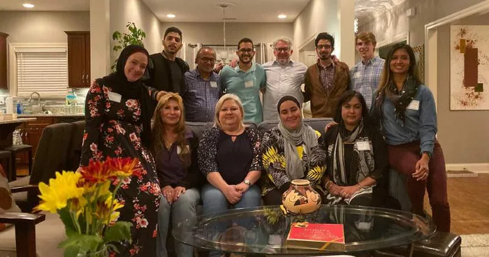 MMY leaders and guests gathered around a dinner table