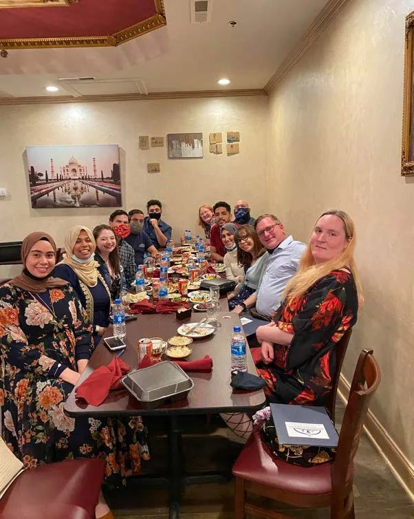 MMY volunteers and guests gathered around a dinner table